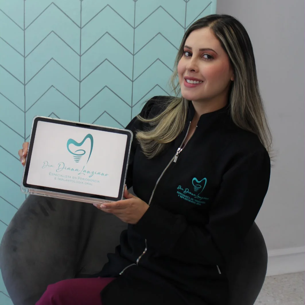 Dr. Diana Lanziano, periodontist and oral implantologist in Bogotá, holding a tablet with her practice logo